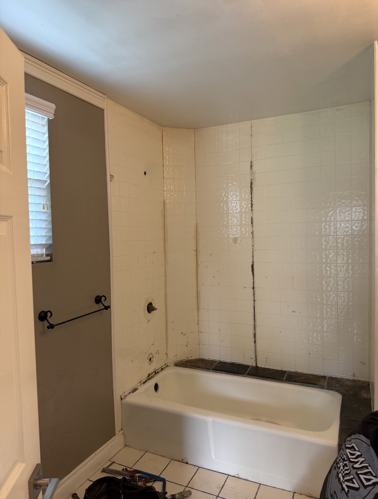 Bathroom before remodel - bare studs and plastic sheeting