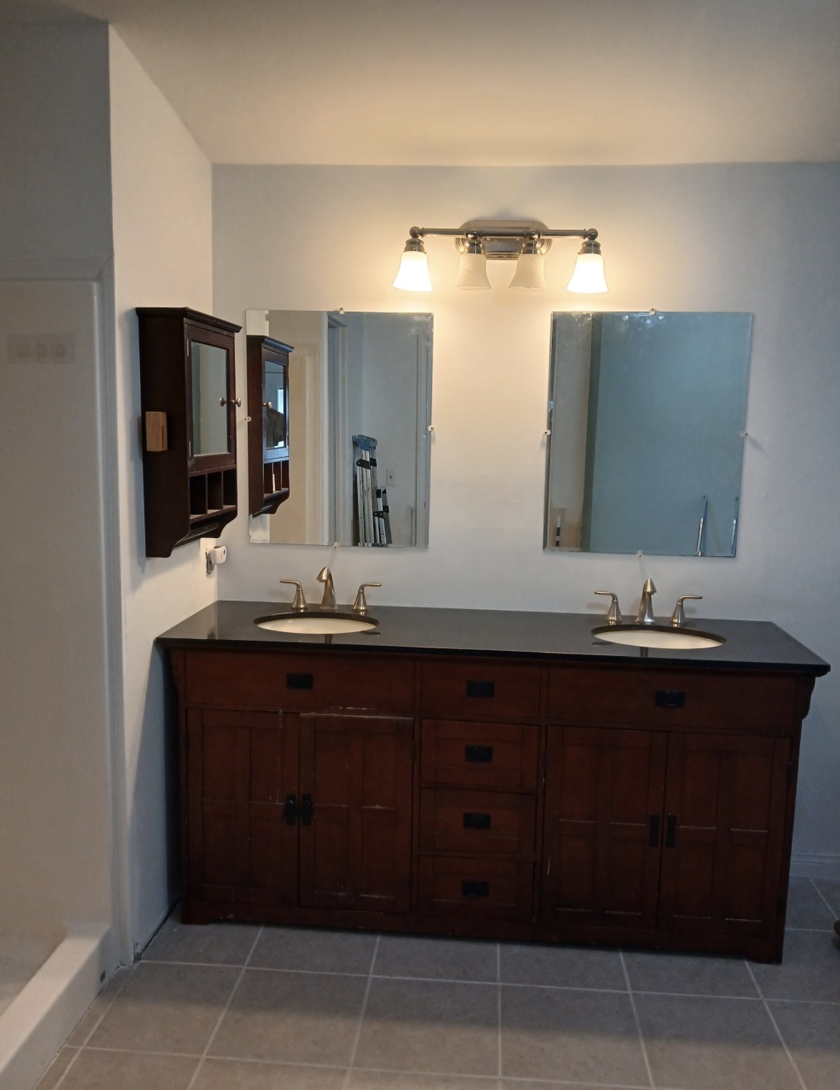 Restored bathroom with new vanity light, mirrors, and clean walls