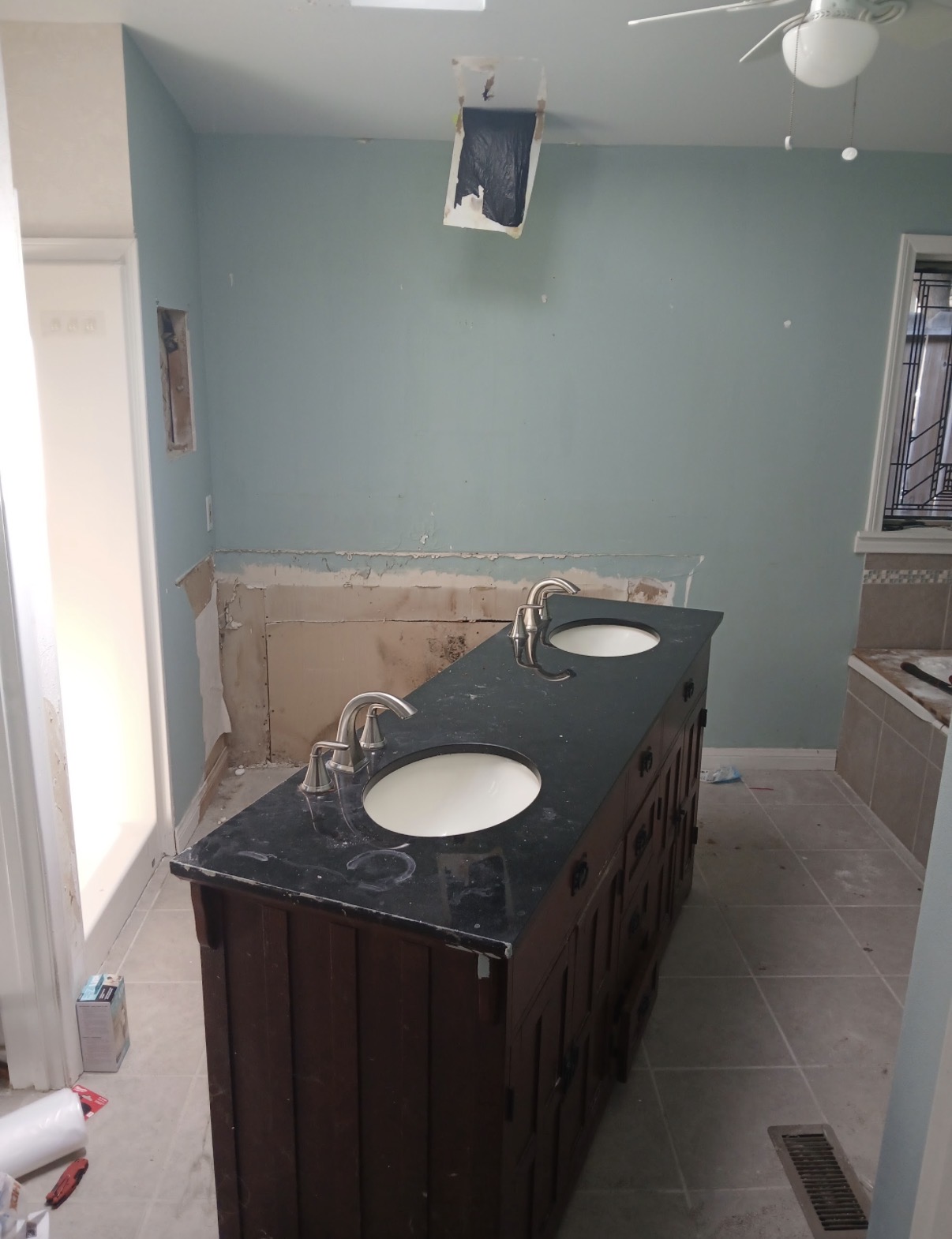 Bathroom mid-renovation with exposed drywall damage