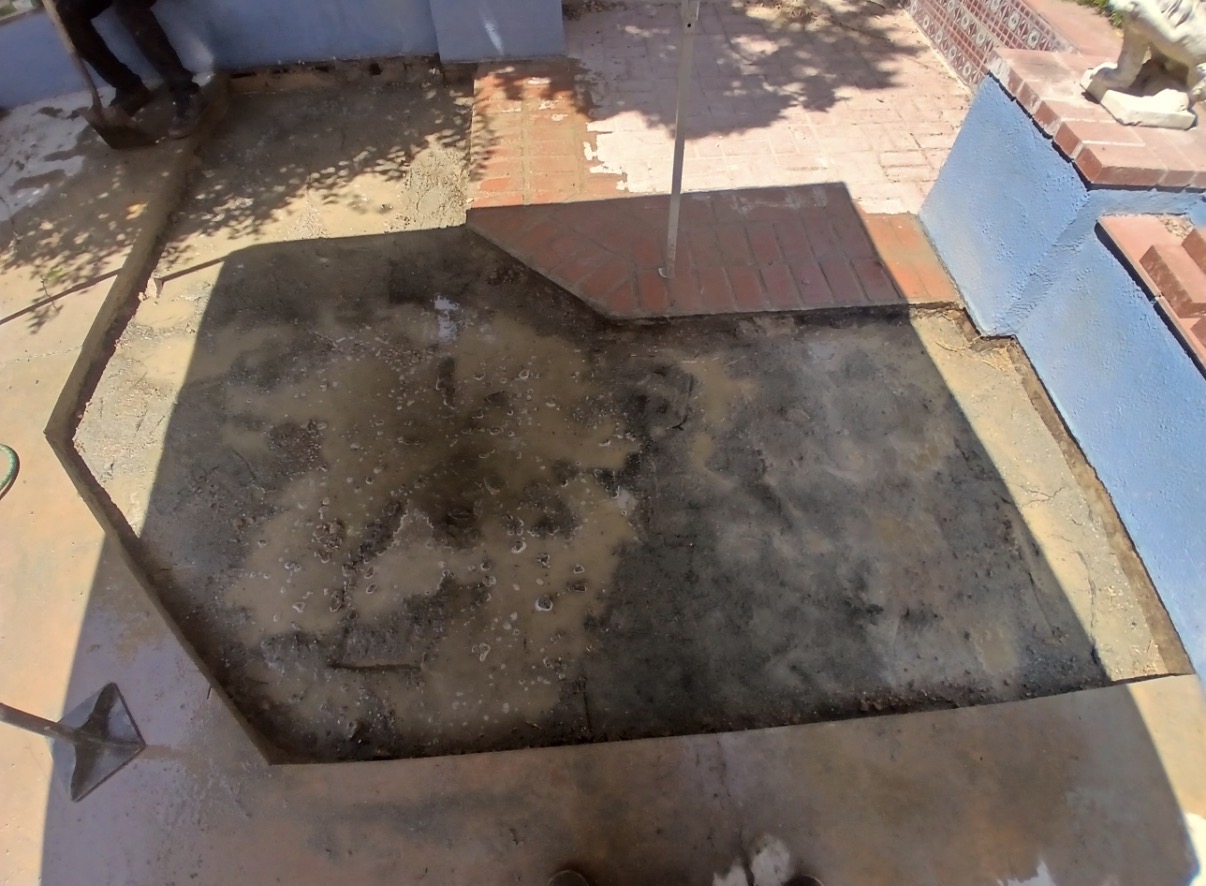 Bare concrete pad with old brick torn out